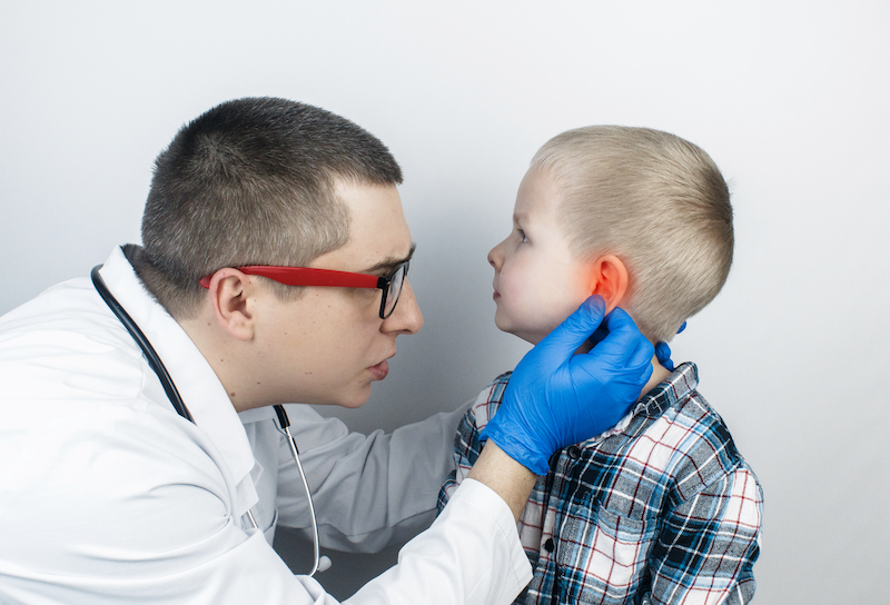 Medico che visita un bambino per dolore all'orecchio